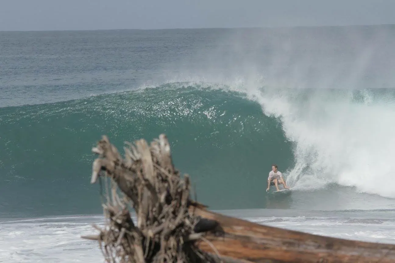 A surfer racing through a heavy barrel at Playa Hermosa