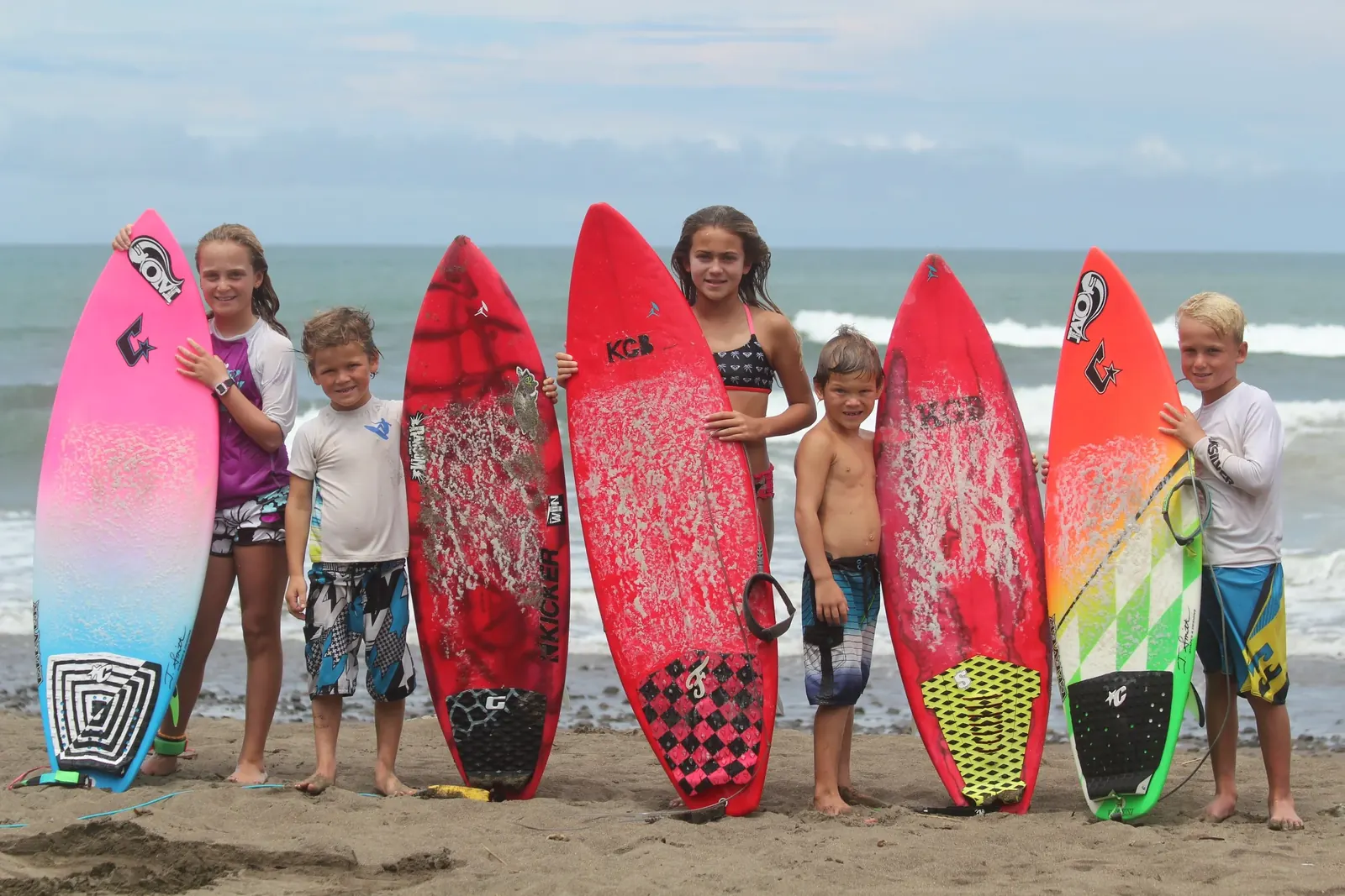 A group of young surfers with their boards on the beach