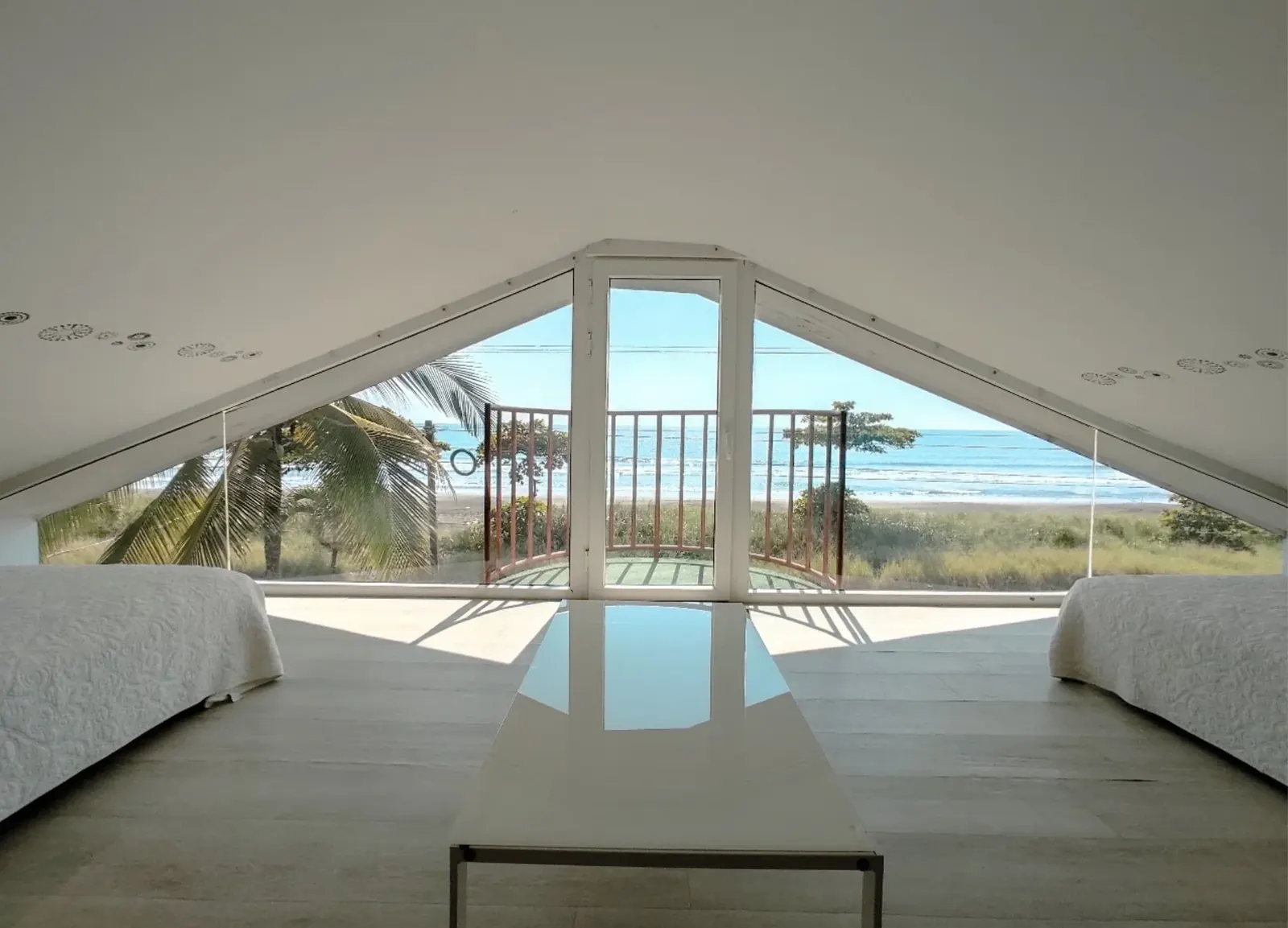 An airy loft bedroom with ocean views