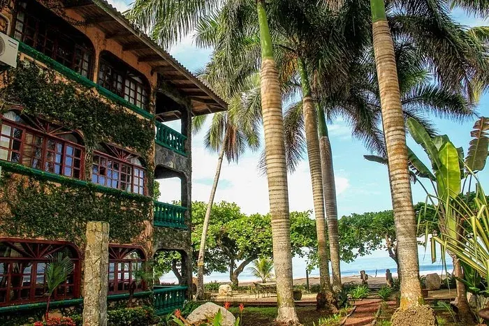 A wooden lodge with balconies among the palms